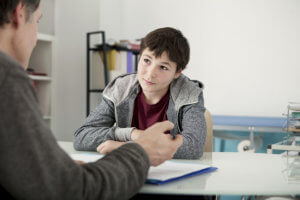 a man talks to a young boy about attending an adolescent rehab program